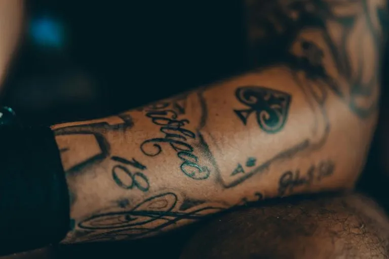 Close-up of forearm tattoos with script lettering, perfect inspiration for an ambigram tattoo generator free design